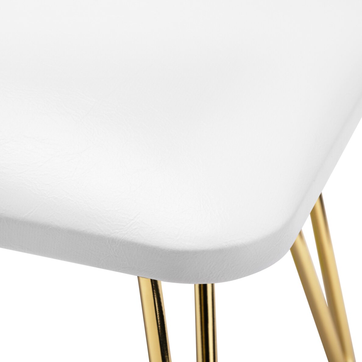 Prim-plan de detaliu cu finisajul de la coltul pernei albe si sistemul de prindere al picioarelor metalice aurii cu design elegant.