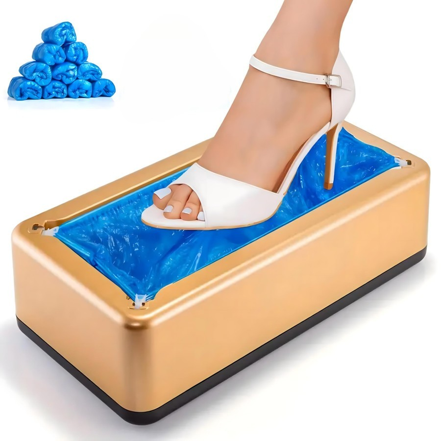 Dispenser automat pentru botosei de culoare auriu cu baza neagra, prezentand un picior de femeie cu sandala alba care apasa pe folia albastra de protectie.

