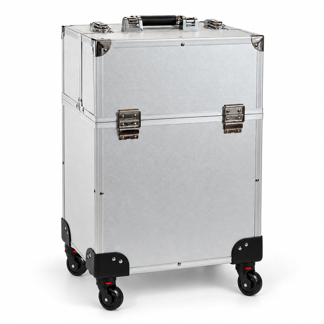 Geanta troler make-up profesionala argintie pentru organizarea si transportul cosmeticelor, vedere din fata si lateral, cu exterior texturat, colturi drepte, rama metalica, doua inchideri cromate, maner superior si roti pivotante negre cu frane rosii.