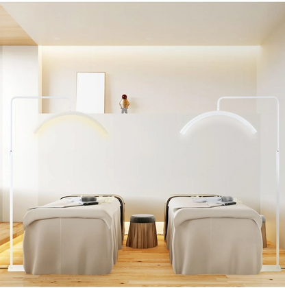 Ambient elegant de salon cu doua paturi de tratament cosmetic iluminate uniform de lampi profesionale LED in forma de arc.