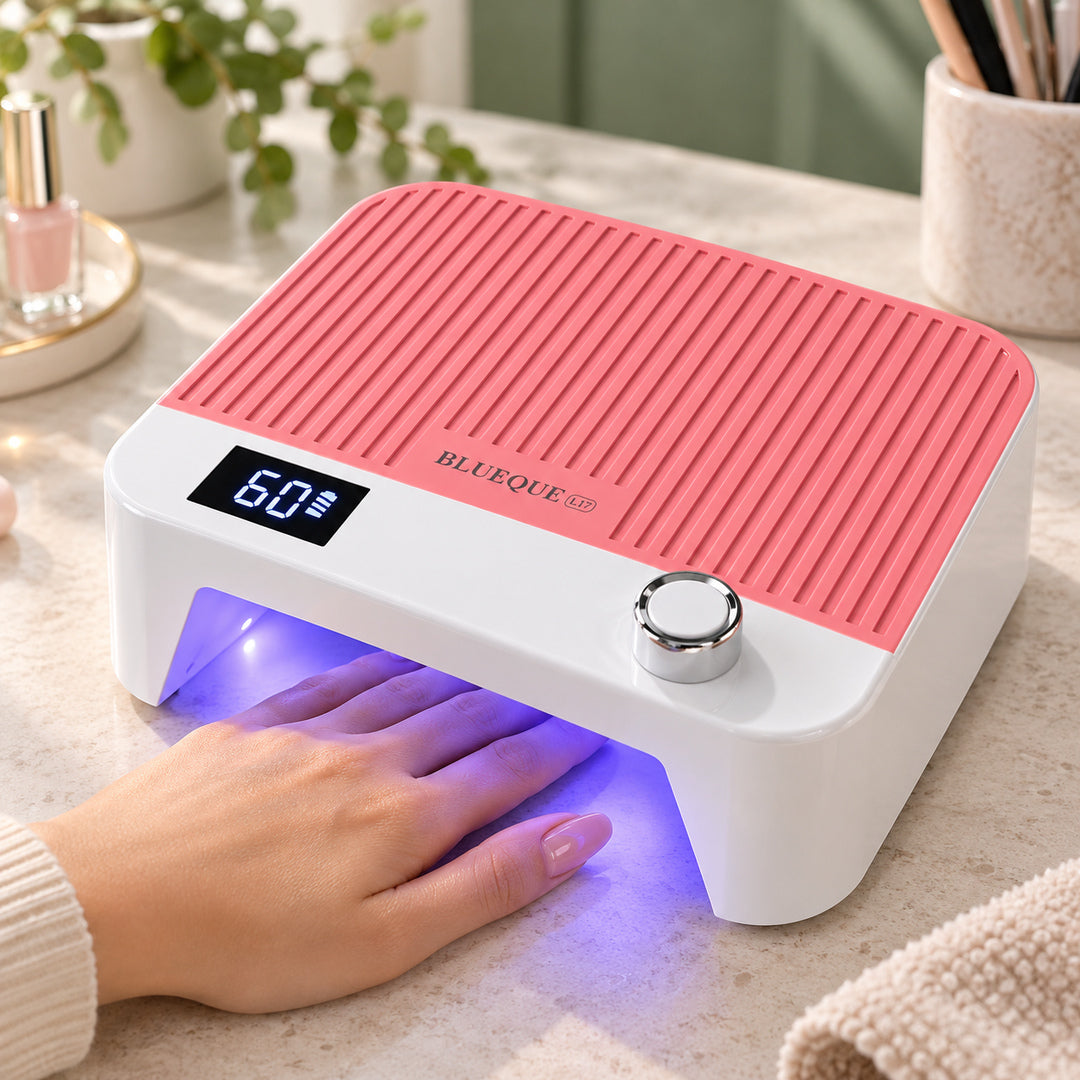 Lampă UV LED reîncărcabilă BQ L17 roz în funcțiune pe masa de manichiură, cu mâna poziționată în interior, lumină violetă, afișaj digital și decor de salon în tonuri naturale.