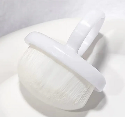 Perie mini pamatuf tip inel pentru manichiura, pozitionata pe o suprafata alba curbata, evidentiand structura din plastic si perii moi.