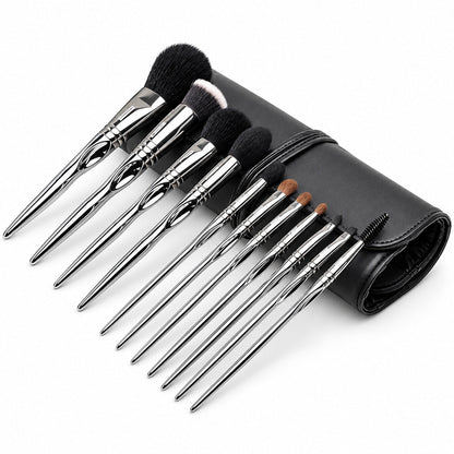 Set 11 pensule profesionale de machiaj Silver Touch, cu mânere argintii, așezate oblic lângă accesoriul negru rulat.